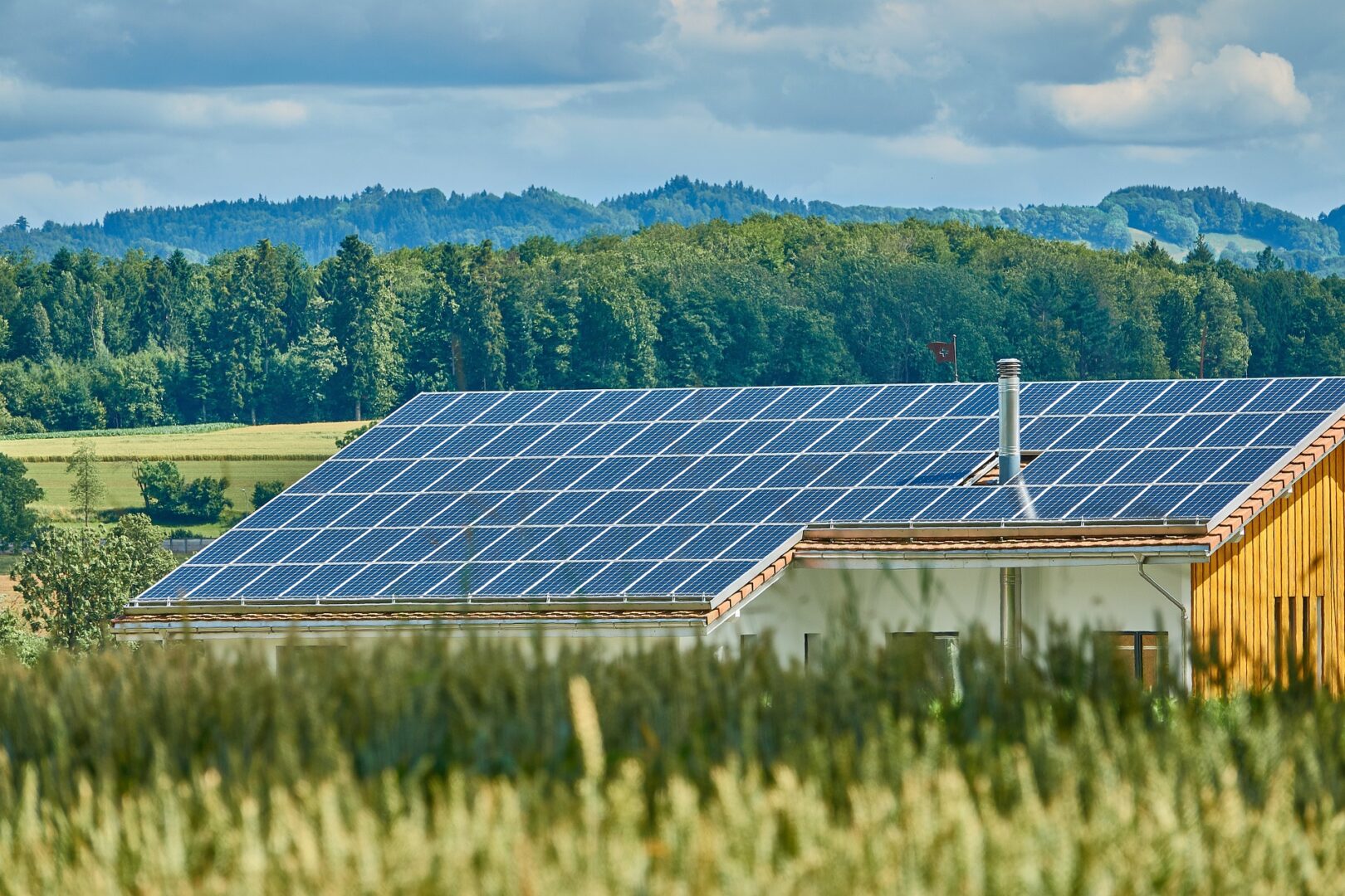 Kleines Haus mit Solarpanel-Dach in der Landschaft