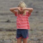 Kind mit Händen vor dem Gesicht
